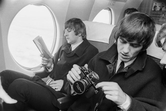The Beatles in New Zealand. Ringo Starr and George Harrison on board an aircraft during their tour of New Zealand, June 1964